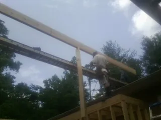 Carpenter setting a ridge beam over a new addition frame — Ice Dam Removal by Roofing Brothers in Stevens Point