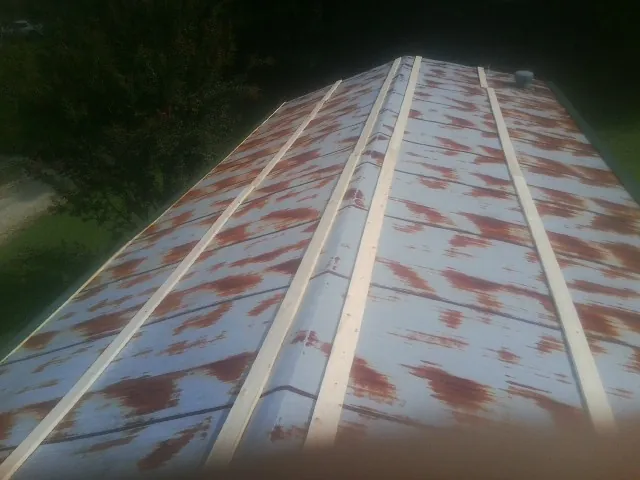 Rusted metal roof panels with new wood purlins before replacement — Storm Damage Roof Repair in Stevens Point by Roofing Brothers