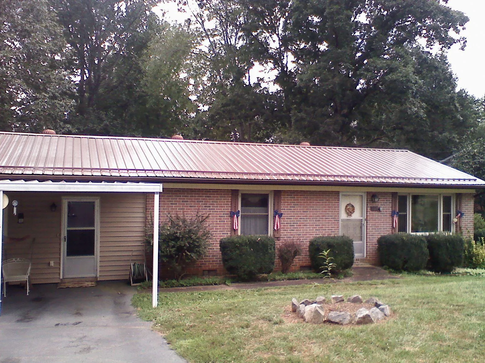 Bronze metal roof and carport on a brick ranch home — Roof Repair work by our crew in Stevens Point